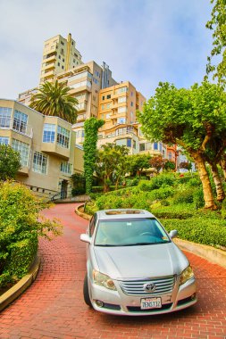 Lombard caddesinde kırmızı tuğlalı yol ve evlerle giden araba görüntüsü