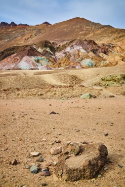 Renkli dağların yanındaki kumlu çöl manzarası