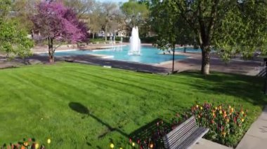 İlkbaharda Fort Wayne, Indiana 'daki Aerial of lale Gardens ve şehir merkezindeki adliye binasının videosu.