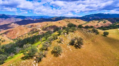 Batı kıyısında kayalar ve yeşil ağaçlarla kaplı ilkbaharda dağların görüntüsü