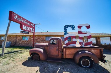 Route 66 'daki eski kamyonun resmi. Motelde Amerikan bayrağı işareti var.