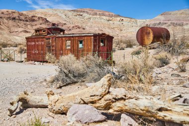 Terk edilmiş Union Pacific hayalet treninin yanında Sandy çölünün resmi.