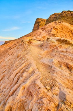 Ölüm Vadisi 'ndeki kızıl kayalık çöl dağının tepesindeki Dar yürüyüş yolunun görüntüsü