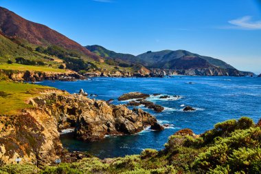 Okyanus kıyısındaki büyük kaya oluşumlarının görüntüsü. Köprü mesafesinde.