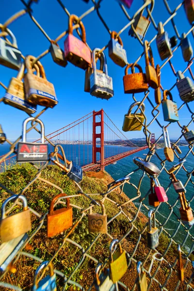 Image of Locks covering fence with opening to Golden Gate Bridge at sunset