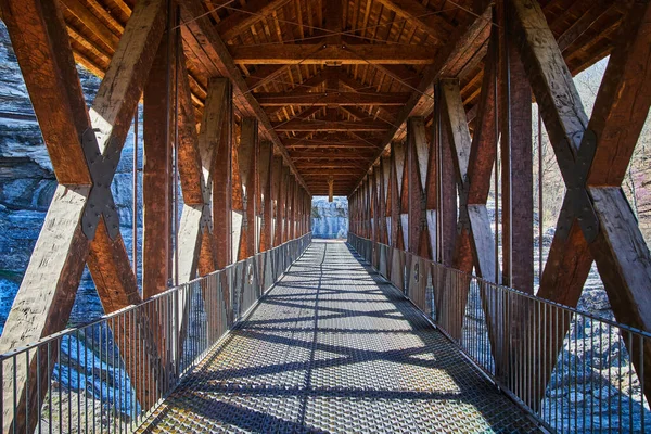 Image of Looking down long walking bridge of wood and metal