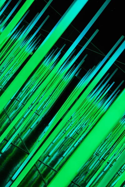 Image of Green LED light poles at angle in abstract