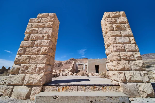 Image of Two large stone pillars and steps leading into abandoned ghost town structure