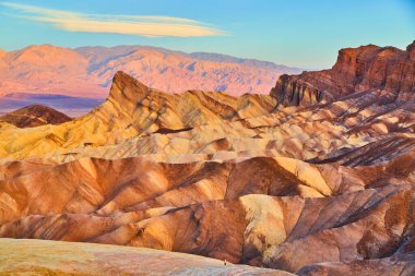 Ölüm Vadisi 'ndeki Zabriskie Point' in görüntüsü. Gün doğumunda çöl dağlarındaki güzel renkli çökelti dalgalarıyla birlikte.