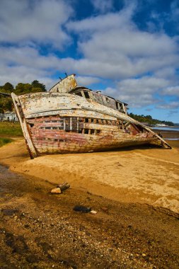 Image of West coast sandy beach with falling apart shipwreck