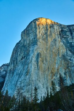 Gün doğarken Yosemite simgesi El Capitan uçurumlarının görüntüsü