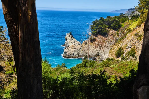 Okyanus Kıyısı Yarımadasındaki Ağaçların Arasından Büyük Kaya Sütunu Ile Görüntü — Stok fotoğraf