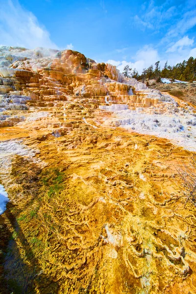 Image of Waterfalls over colorful terraces with snow in Yellowstone winter