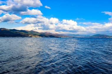 Deniz koyunun temiz su ve güzel bulutlarla güzel havası var.