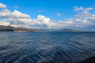 Deniz koyunun temiz su ve güzel bulutlarla güzel havası var.