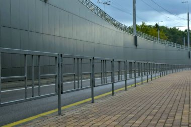 Üstgeçidin arkasındaki kaldırım boyunca bir çit var. Mesafeye giden çizgilerin yönünü belirliyor. Yüksek kalite fotoğraf