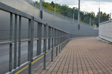 Üstgeçidin arkasındaki kaldırım boyunca bir çit var. Mesafeye giden çizgilerin yönünü belirliyor. Yüksek kalite fotoğraf