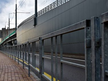 Üstgeçidin arka planında kaldırım boyunca bir çit var. Mesafeye giden çizgilerin yönünü oluşturur.