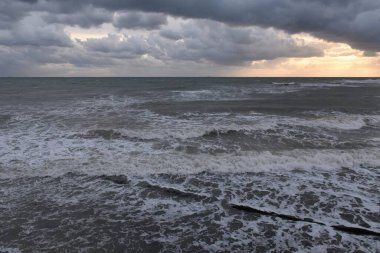 Akşamları, gün batımında pembe bulutların altında denizde bir fırtına olur. Gün batımında sahil boyunca bir yürüyüş.