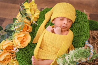 Sarı battaniye ve başörtüsüyle kaplı şirin bir kız yeşil örgü örüyor sarı çiçekler yeşil yapraklar