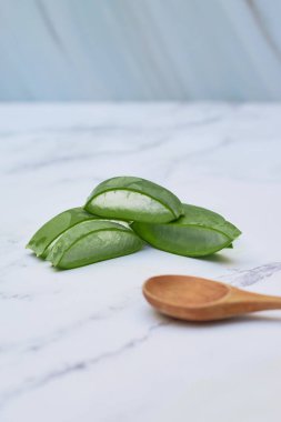 Beyaz mermer bir masada aloe vera dilimleri. Cilt bakımı kavramı.