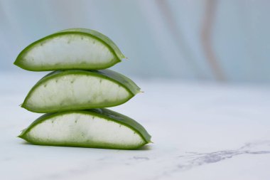 Beyaz mermer bir masada aloe vera dilimleri. Cilt bakımı kavramı.