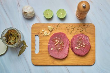 Tahta kesme tahtasında mermer masada taze çiğ ton balığı bifteği. Üst görünüm.
