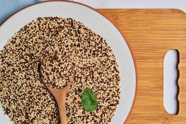 Çiğ kinoa tanelerini porselen bir tabağa karıştırdım. Vejetaryen gıda konsepti.