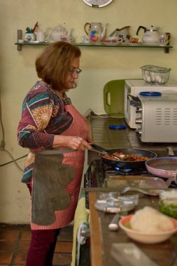 Latin büyükanne geleneksel Meksika mutfağında taco pişirir..