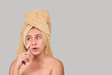 Yarı çıplak latin kadın. Yüzüne yeşim taşlı masaj yapıyor.