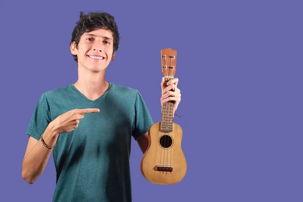 Jovem Latino Mostra Ukulele Isolado Fundo Plano — Fotografia de Stock