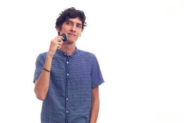 Traş makinesi kullanan genç bir adam. Beyaz arkaplanda izole.