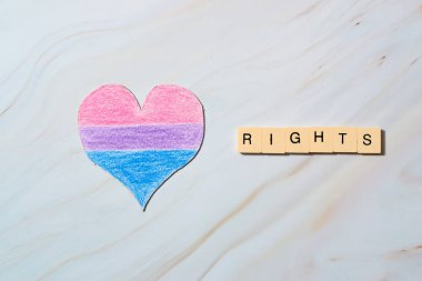 Biseksüel bayrağı olan bir kalp. Gurur, eşitlik ve haklar.