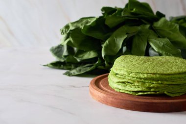 Ispanaklı yeşil tortilla, dürümler için yuvarlak boş tortilla, modaya uygun Meksika yemekleri, sağlıklı atıştırmalık konsepti