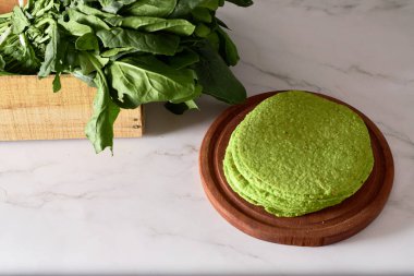 Ispanaklı yeşil tortilla, dürümler için yuvarlak boş tortilla, modaya uygun Meksika yemekleri, sağlıklı atıştırmalık konsepti