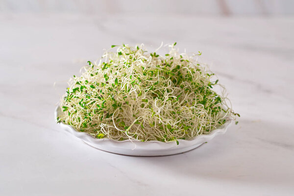 куча люцерны на белом мраморном столе.