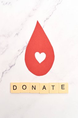 Concept of blood donation. Red paper drop icon, inviting to donate.