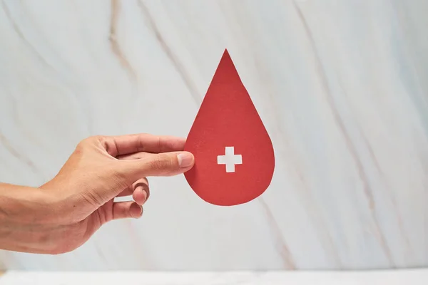 Blood Donation Concept. Help, Care, Love, Support. Hand Holding a Red Drop