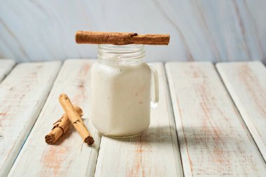 Fresh horchata with cinnamon in glass on rustic table