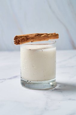 Fresh horchata with cinnamon in glass on rustic table