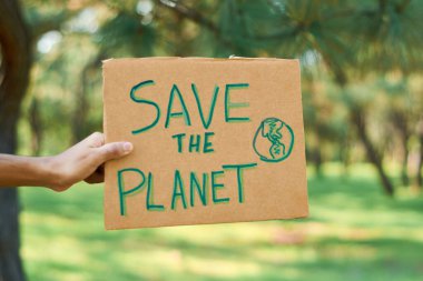 Young latin teenage man protests in the forest to save the planet.