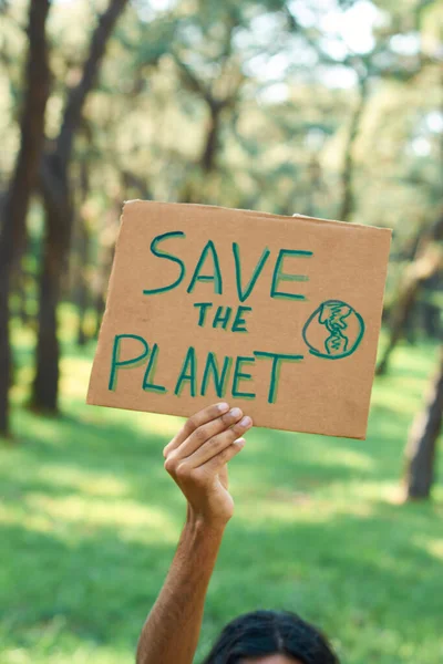Young latin teenage man protests in the forest to save the planet.