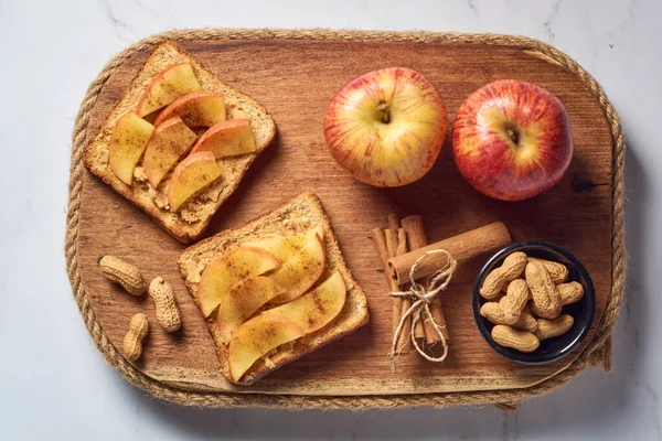 Toasts with peanut butter and apple. Healthy vegetarian breakfast concept.