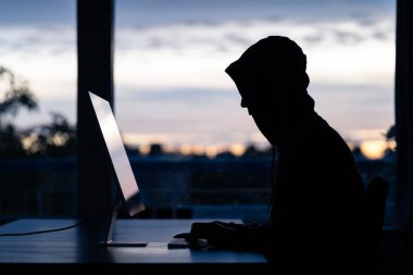 Bir masaüstü bilgisayarında dijital suç işleyen bir hacker.