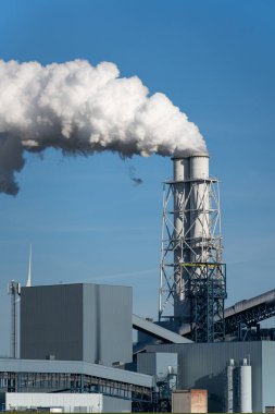 Eemshaven 'da fosil yakıt (kömür) enerji santrali ve rüzgar türbinleri güç üretiyor. Enerji geçiş kavramı.