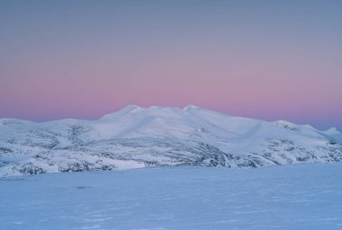 İsveç Laponya dağlarında kışın pembe bir alacakaranlık.