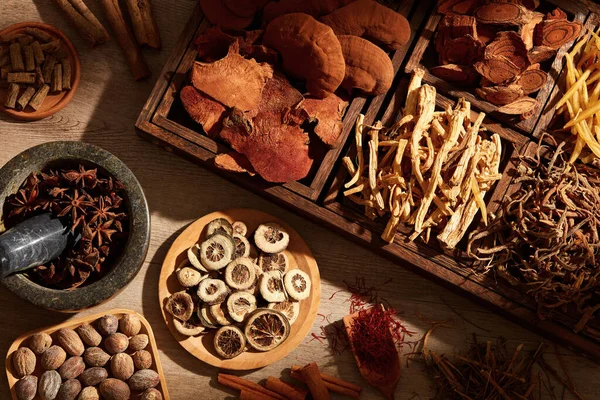 Traditional chinese medicine with herb and spices in brown wooden background mortar and pestle , for medicine advertising , photography traditional medicine content