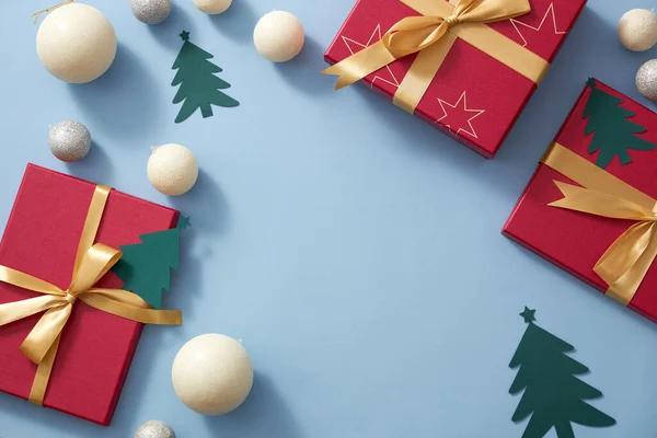 クリスマスの装飾 松の木の輝く真珠とリボン付きの赤いギフトボックス 陽気なクリスマス休暇の広告のための空白のスペースを持つライトブルーの背景 — ストック写真