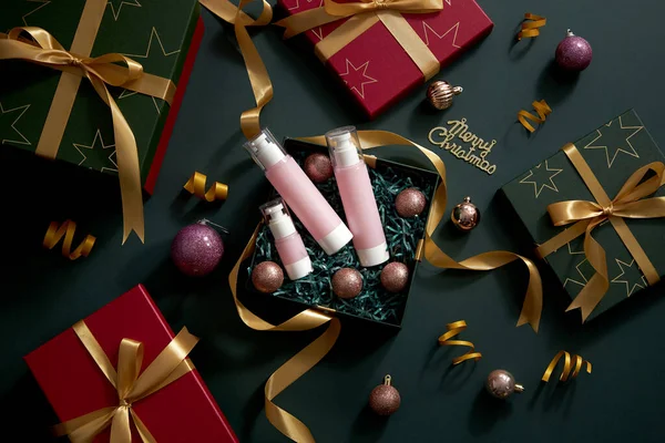 クリスマスの装飾 赤と緑のギフトボックスと濃い青の背景のトップビュー黄色のリボンは 休日の広告 写真の休日のコンテンツのための化粧品ギフトボックスと真珠の輝き — ストック写真