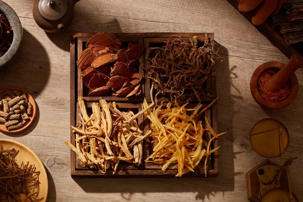 茶色の木製の背景モルタルや杵でハーブやスパイスと伝統的な中国医学を見る 医学広告のための 写真伝統的な医学の内容 — ストック写真
